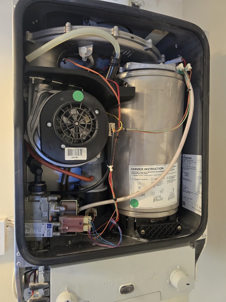 Boiler casing removed showing fan, gas valve and wiring during a repair