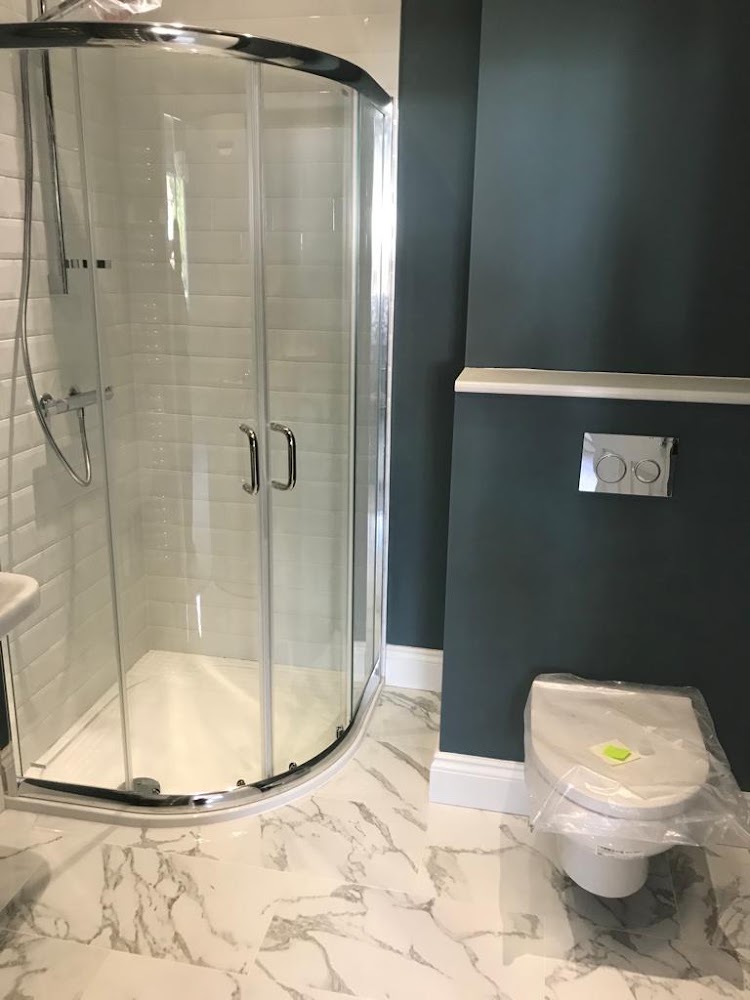 Quadrant shower enclosure and wall-hung toilet on marble-effect floor